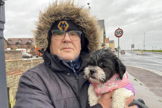 Daisy gets a cuddle from owner Dave Gregory as they make their way home during Storm Gerrit. Picture by FRANK REID