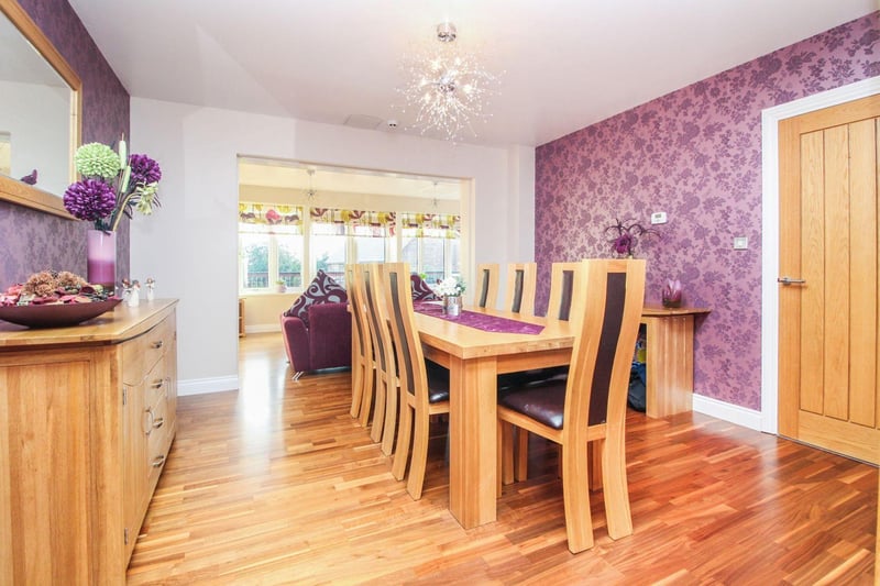 The modern dining room boasts oak laminate flooring, underfloor heating, and access to both the garden room and kitchen area.