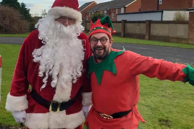 Santa and one of his elves Lee Wilmot who went around the town with charity Miles For Men delivering presents to children and families.