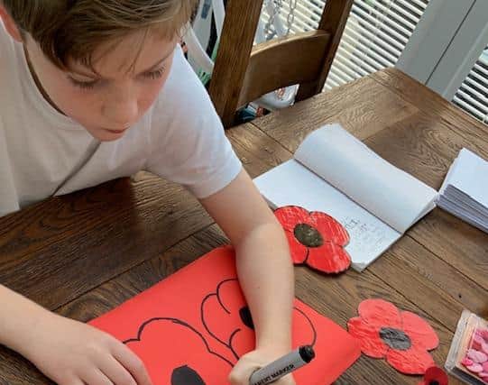 Harry making a new batch of poppies for sale.