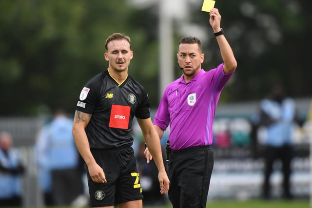 Referee Paul Howard shows a yellow card to Jack Diamond. Harrogate have had two players sent off this season.