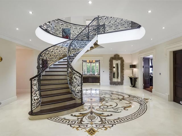 This expansive entrance hall has an impressive spiral staircase and doors that access all ground floor rooms.