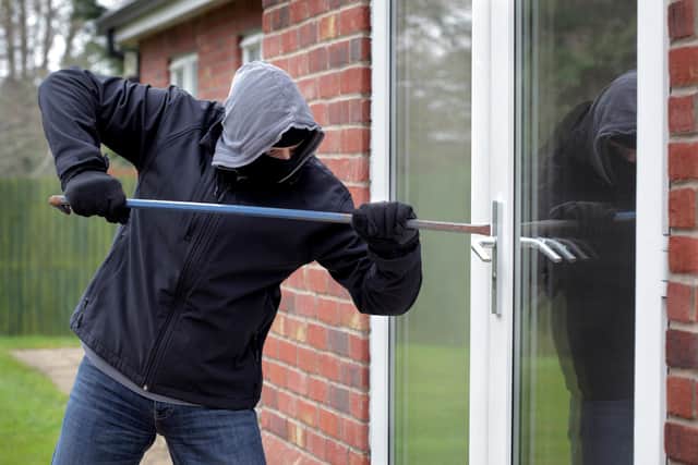 Burglar breaking into a house window with a crowbar. Picture: Adobe Stock