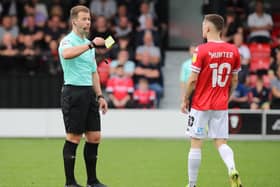 Referee Anthony Backhouse shows a yellow card to Ash Hunter of Salford City for simulation during the Sky Bet League Two match between Salford City and Northampton Town  at Peninsula Stadium on September 25, 2021 in Salford, England. (Photo by Pete Norton/Getty Images)