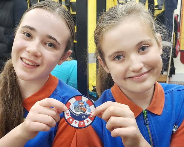 Alice Harper (left) and Mia Dale are pictured with one of the Mayday Mayday badges. Photo credit Tom Collins RNLI.