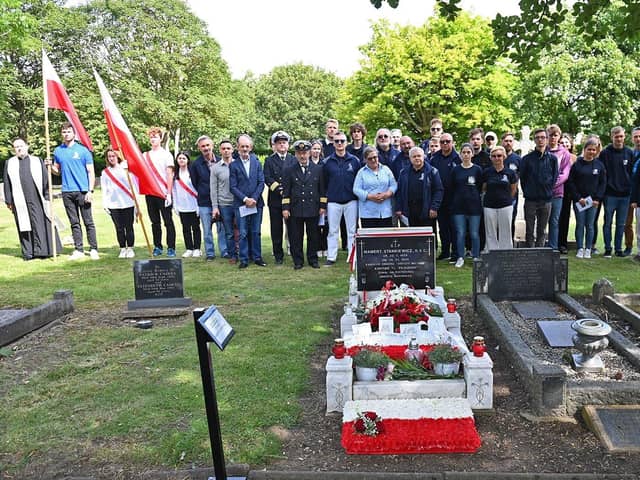 Crew and members of the Polish community gather at the grave of Captain Mamert Stankiewicz at a memorial service.