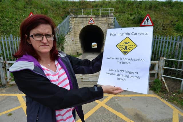 Councillor Rachel Creevy holding the Rip Tide warning poster near Steetley beach. Picture by FRANK REID
