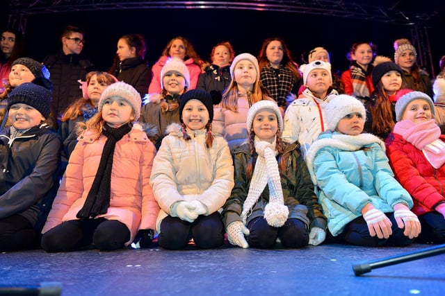 Singers from Miss Toni's Academy of Singing & Performing Arts wait to sing on stage before the Christmas lights switch on in 2017.