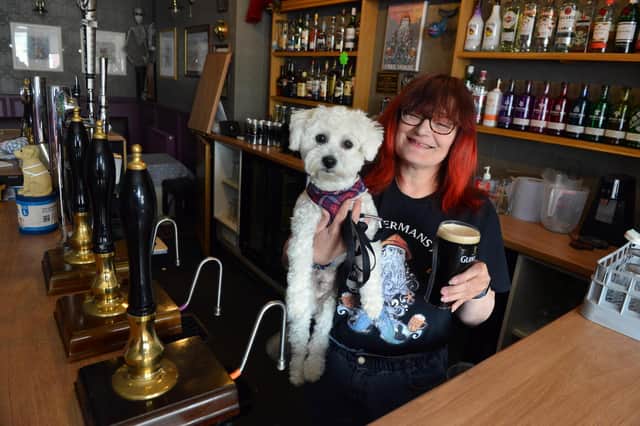 The Fishermans Arms landlady Hazel Whitelock with dog Sunny behind the bar.