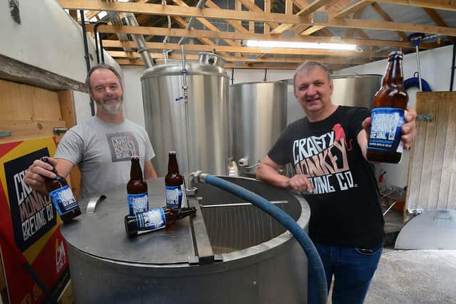 Pat Garrett, left, and Gary Olvanhill, from the Crafty Monkey Brewing Company, with one of the first bottles of Cloudburst.