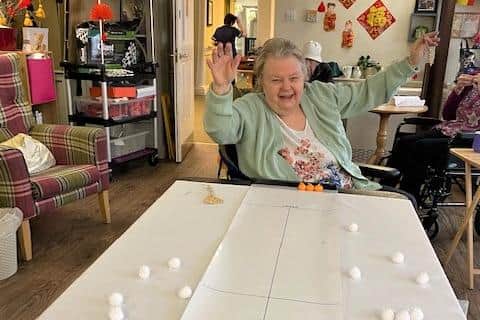 Resident Freda Manning going for gold in the tabletop curling event.