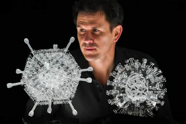 Artist Luke Jerram with his glass sculpture of the Oxford-AstraZeneca coronavirus vaccine. Photo by Finnbarr Webster/Getty Images
