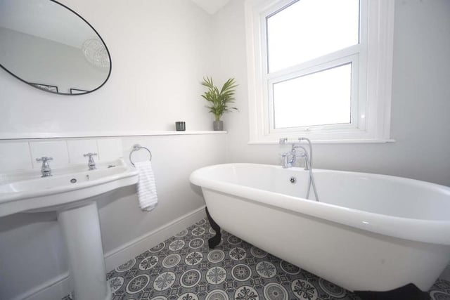 The stylish family bathroom features a free standing Victorian roll top bath.