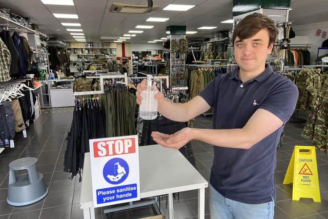 Pools Surplus Store's Jack Hanlon making use of the hand sanitiser station inside the Catcote Road store. Picture by FRANK REID