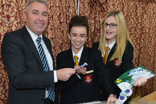 Headteacher Stephen Hammond hands over his cash at the Tombola stall to pupils Megan Benson and Rebecca Banks (right) during the English Martyrs School and Sixth Form Children In Need event.