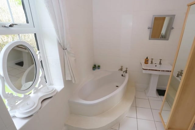 The family bathroom features a corner bath and a separate shower.