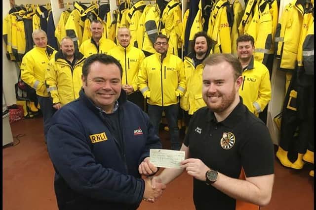 Hartlepool RNLI Coxswain Robbie Maiden pictured receiving the cheque from Mark O'Neill./Photo: RNLI/Tom Collins