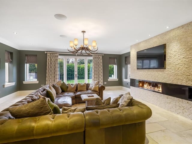This large family room has an impressive media wall and doors leading out into the garden.