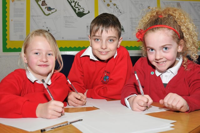 Rossmere Primary School pupils Emma Harman, Curtis Reece Rowledge and Neeve Jessop write down the lyrics to their own song in 2013.