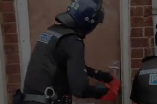 An officer breaks down the door. image: Cleveland Police