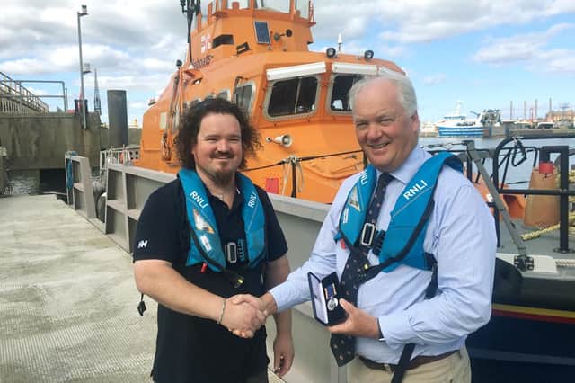 RNLI chief executive Mark Dowie presenting volunteer crew member Matt Blanchard with his long service award at the Ferry Road lifeboat station. Picture Tom Collins.