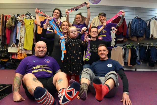 Bella Gill, six, with Micky Day and Darren Cliff (front) parents Donna Fenwick and Daniel Gill (centre) and members of the Miles for Men team.
