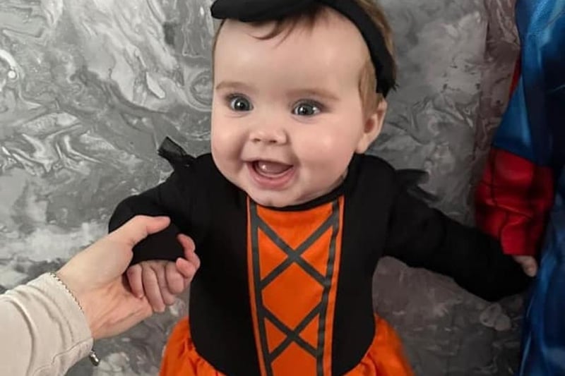 Thalia, seven months, dressed up as a witch for her first Halloween.