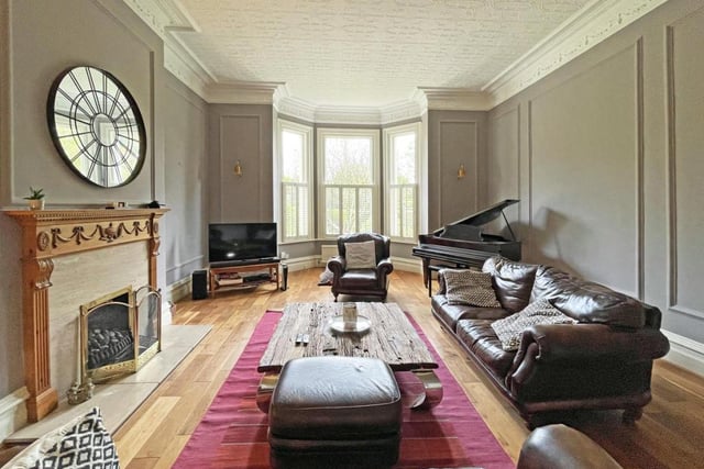 The spacious living room is flooded with light and has a cosy fireplace.