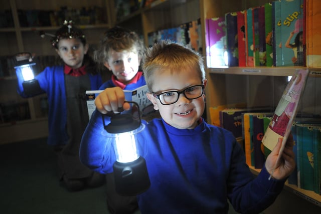Throston Primary School pupils Charlie Hughes, George Todd and Maisie MacRae reading by torchlight, as part of an Eco day at the school.