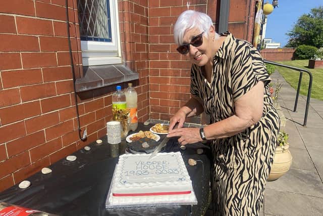 Rosemary May, the great granddaughter of builder Colonel Lieutenant William Thomlinson, cutting a cake to commemorate the 100th birthday of the Vesper House bungalows, in Queen Street, Seaton Carew.
