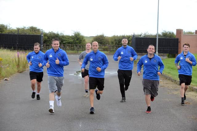 Miles for Men FC football team arrive at the family fun day after completing the 5km race.