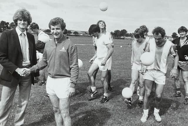 Council trainee Alastair Rae, far left, shakes Hartlepool United manager Mick Docherty's hand in 1983 after brokering a deal for the club to use council pitches for training. Also pictured are Andy Linighan, who is the further back of the two players next to Alastair, Phil Brown, who is wearing a plain T-shirt in the centre of the photo and John Bird, far right.