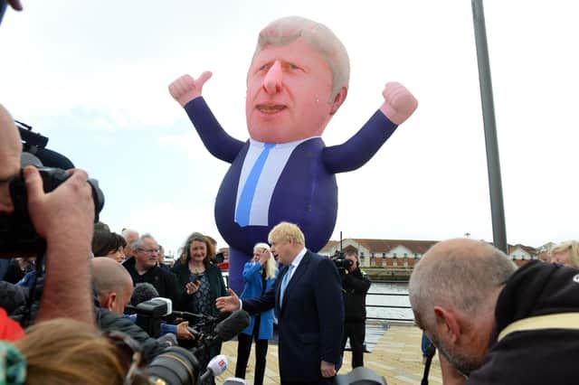 A giant inflatable of Boris Johnson stands over the PM as he visits Jackson's Wharf, Hartlepool, following the by-election victory to congratulate new MP Jill Mortimer.
