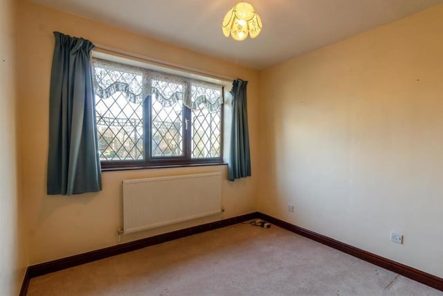The second bedroom has fitted wardrobes with hanging rails, shelving and sliding doors. There is a radiator and a double-glazed window to the back of the bungalow.