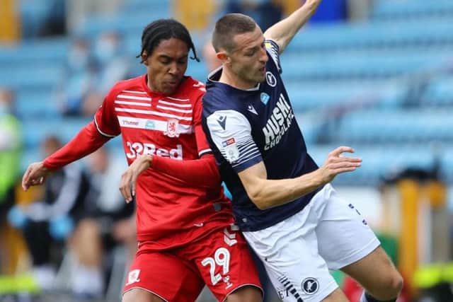 Middlesbrough's Djed Spence challenges for possession against Millwall's Murray Wallace.