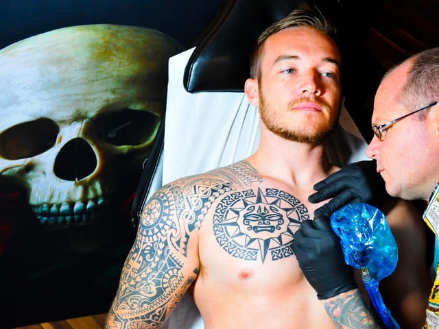 Paul Egan (right), owner of Wishful Inking tattoo studio on Park Road working on a detailed design in 2014.