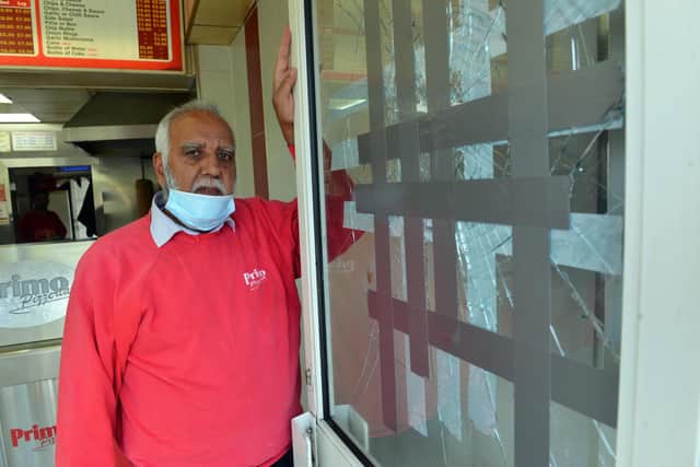 Primo Pizzeria owner Mubashar Ahmed with the damaged window following attack