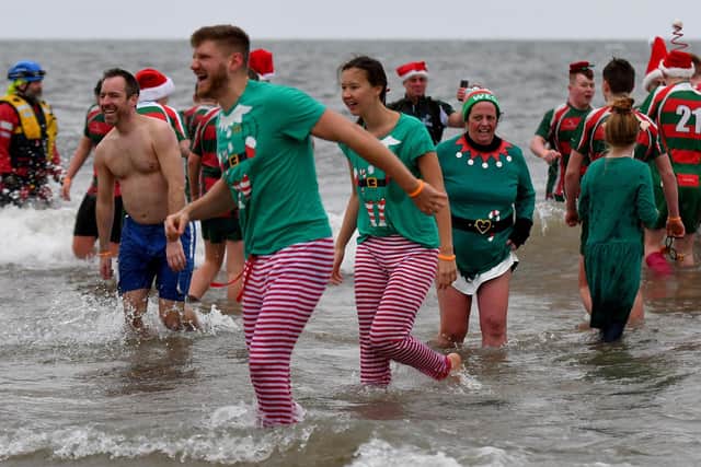 The dip attracts hundreds of people mingling and all running into the sea at once. Picture by FRANK REID