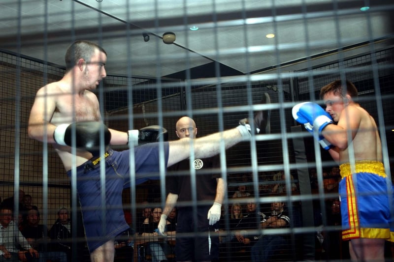 Men take part in cage fighting in 2003.