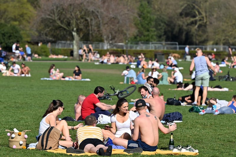 People enjoy the sunshine in Battersea Park, central London on March 30, 2021, as England's third Covid-19 lockdown restrictions eased on March 29, allowing groups of up to six people to meet outside. (Photo by JUSTIN TALLIS/AFP via Getty Images)