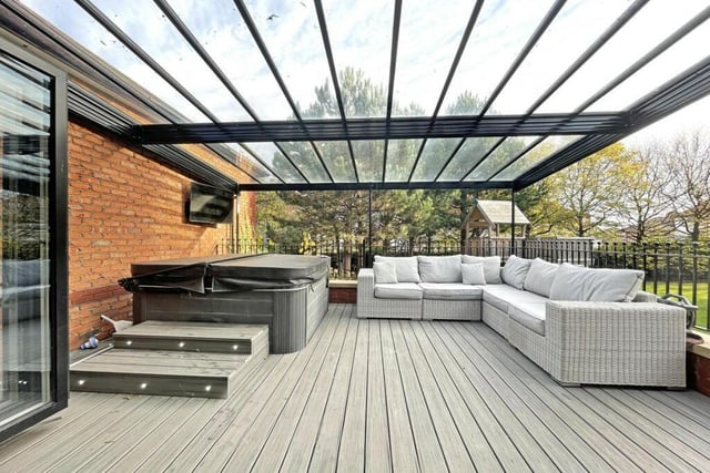 This large outdoor terrace is covered with a clear roof.
