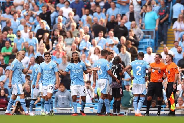 MANCHESTER, ENGLAND - SEPTEMBER 02: Nathan Ake of Manchester City reacts as Match Referee Michael Oliver consults Assistant Referee Stuart Burt before allowing Manchester City's second goal during the Premier League match between Manchester City and Fulham FC at Etihad Stadium on September 02, 2023 in Manchester, England. (Photo by Lewis Storey/Getty Images)
