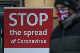 A man walks past a coronavirus advice sign.
