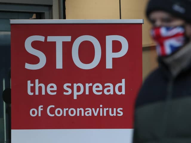 A man walks past a coronavirus advice sign.