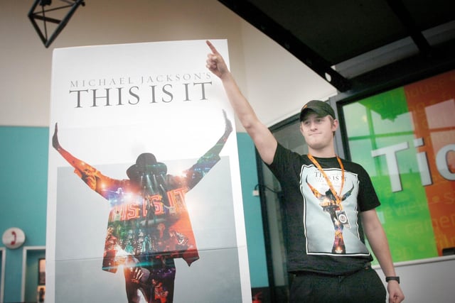 Cinema assistant, Gregg Owens, poses next to the Michael Jackson poster in 2009.