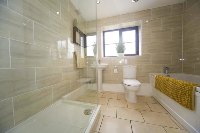 The huge family bathroom features an oversized shower enclosure and a bath.