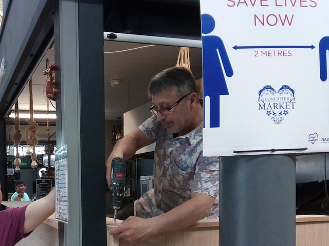 A workman helps ready a food stall for re-opening next month at the Wool Market