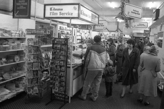 A busy scene around the Binns store film service counter.