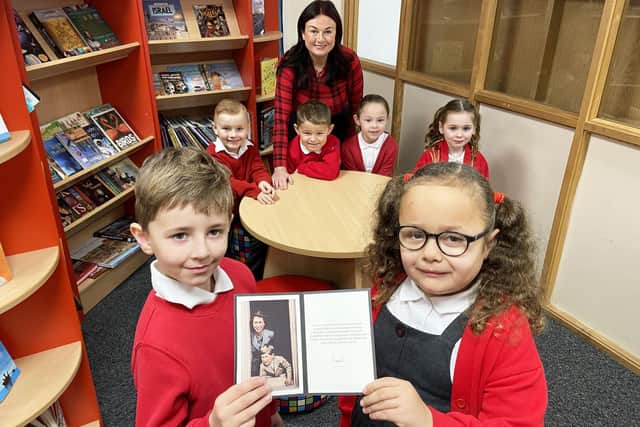 Rossmere Academy pupils Olivia Wilson and Harry Ashton holding the photograph they received from King Charles III, along with Oliver MacPhee, Daniel Athey, Imogen McBan, Lydia Harrison and teacher Mrs Sarah Booth-Kilby.