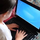 A child using a laptop computer. Campaigners are threatening legal action against the Government if it fails to step up its efforts to ensure all children can access remote education during the lockdown.